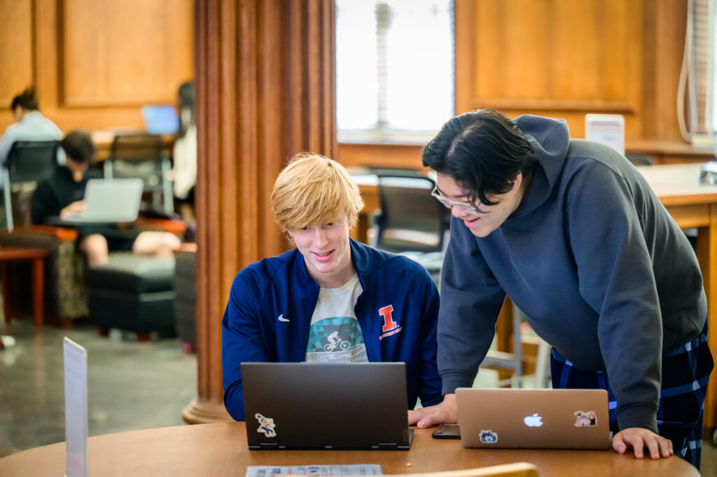 Two students on laptops to demonstrate a photo of software accounts after graduation at U of I